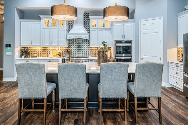 4197 Glade Wood Loop, New Port Richey, FL 34655 - kitchen featuring premium range hood, dark wood-style flooring, light countertops, and decorative light fixtures