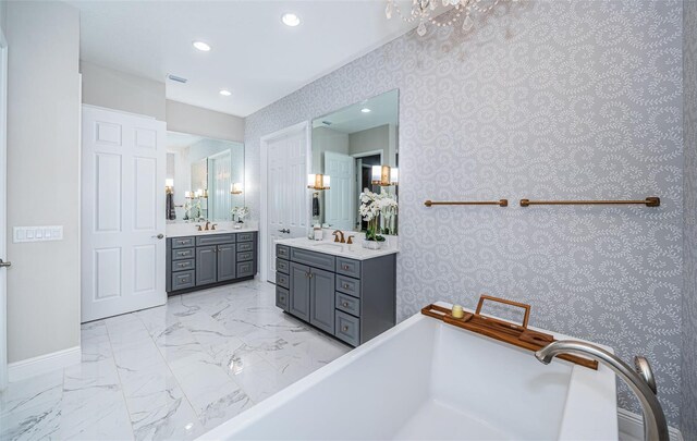 4197 Glade Wood Loop, New Port Richey, FL 34655 - bathroom with two vanities, a freestanding bath, recessed lighting, and wallpapered walls