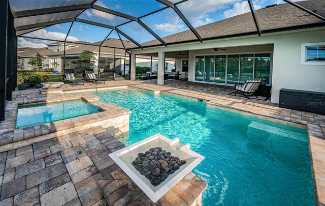 4197 Glade Wood Loop, New Port Richey, FL 34655 - view of pool featuring a patio, a ceiling fan, a fire pit, a pool with connected hot tub, and glass enclosure