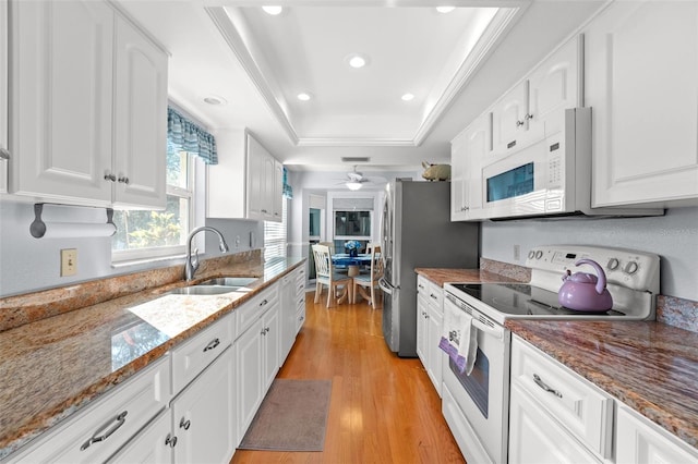 2342 Countryside Dr, Spring Hill, FL 34606 - kitchen with white appliances, white cabinets, a tray ceiling, and recessed lighting