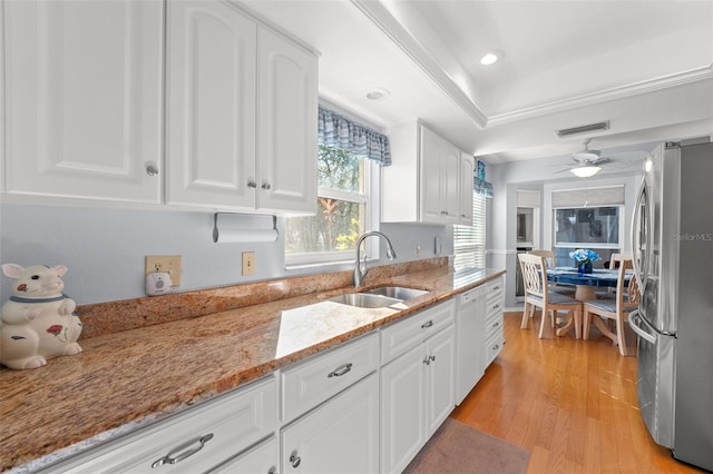 2342 Countryside Dr, Spring Hill, FL 34606 - kitchen with freestanding refrigerator, white dishwasher, light wood-style floors, and white cabinetry