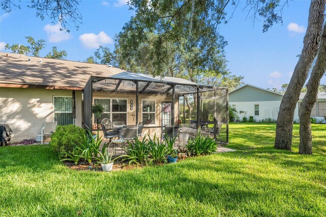 2342 Countryside Dr, Spring Hill, FL 34606 - back of property featuring a yard, glass enclosure, stucco siding, and a patio area