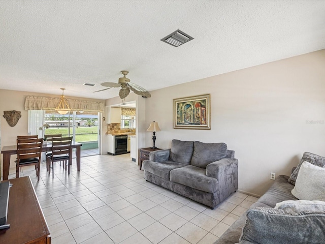 4567 Great Lakes Dr S, Clearwater, FL 33762 - living area featuring a ceiling fan, a textured ceiling, light tile patterned flooring, and wine cooler