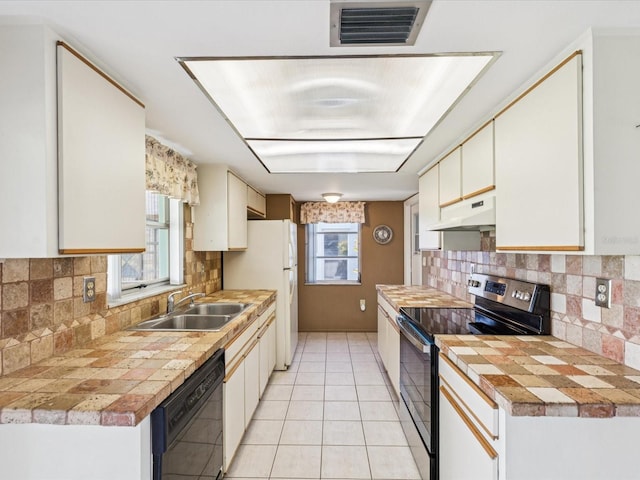 4567 Great Lakes Dr S, Clearwater, FL 33762 - kitchen featuring stainless steel electric range, dishwasher, under cabinet range hood, freestanding refrigerator, and light tile patterned floors