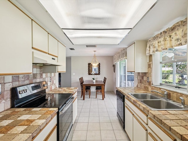 4567 Great Lakes Dr S, Clearwater, FL 33762 - kitchen featuring stainless steel electric range oven, under cabinet range hood, black dishwasher, tasteful backsplash, and light tile patterned flooring