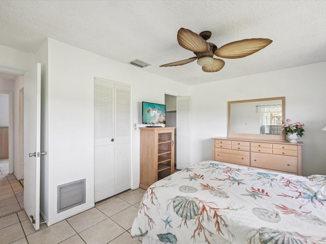 4567 Great Lakes Dr S, Clearwater, FL 33762 - bedroom with light tile patterned floors, a closet, a textured ceiling, and a ceiling fan