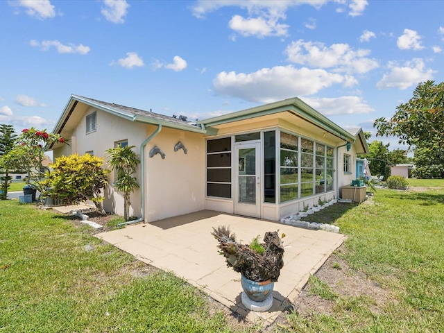 4567 Great Lakes Dr S, Clearwater, FL 33762 - back of property with stucco siding, a sunroom, a patio area, and a yard
