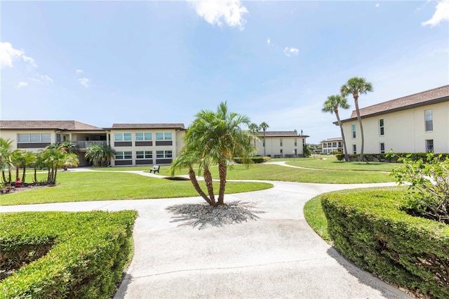 4754 Marine Pkwy Unit 103, New Port Richey, FL 34652 - view of home's community featuring a lawn, curved driveway, and a garage