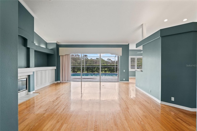 4351 Mallard Lake Dr, Spring Hill, FL 34609 - unfurnished living room with ornamental molding, built in features, wood finished floors, and a tiled fireplace