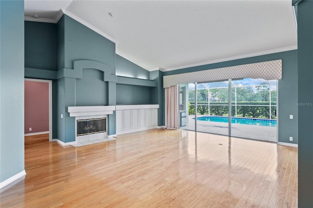 4351 Mallard Lake Dr, Spring Hill, FL 34609 - unfurnished living room featuring vaulted ceiling, wood finished floors, crown molding, and a fireplace