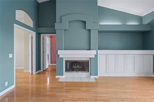 4351 Mallard Lake Dr, Spring Hill, FL 34609 - unfurnished living room featuring crown molding, light wood-type flooring, and a tiled fireplace