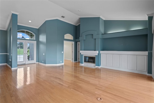 4351 Mallard Lake Dr, Spring Hill, FL 34609 - unfurnished living room with french doors, wood finished floors, a fireplace with flush hearth, crown molding, and high vaulted ceiling