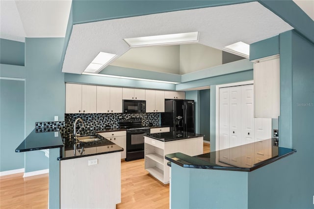 4351 Mallard Lake Dr, Spring Hill, FL 34609 - kitchen with black appliances, a peninsula, dark countertops, decorative backsplash, and light wood-type flooring