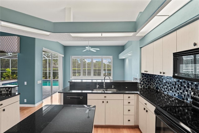 4351 Mallard Lake Dr, Spring Hill, FL 34609 - kitchen featuring black appliances, light wood-style flooring, a peninsula, tasteful backsplash, and ceiling fan