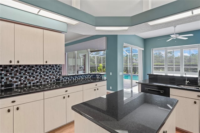 4351 Mallard Lake Dr, Spring Hill, FL 34609 - kitchen with decorative backsplash, a center island, dark stone counters, ceiling fan, and dishwashing machine