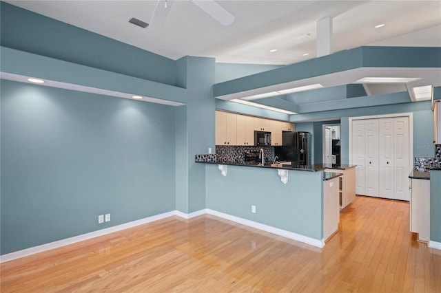 4351 Mallard Lake Dr, Spring Hill, FL 34609 - kitchen with black appliances, a peninsula, decorative backsplash, a kitchen breakfast bar, and recessed lighting