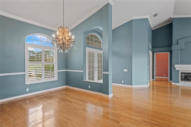 4351 Mallard Lake Dr, Spring Hill, FL 34609 - unfurnished dining area with french doors, a chandelier, wood finished floors, crown molding, and a towering ceiling