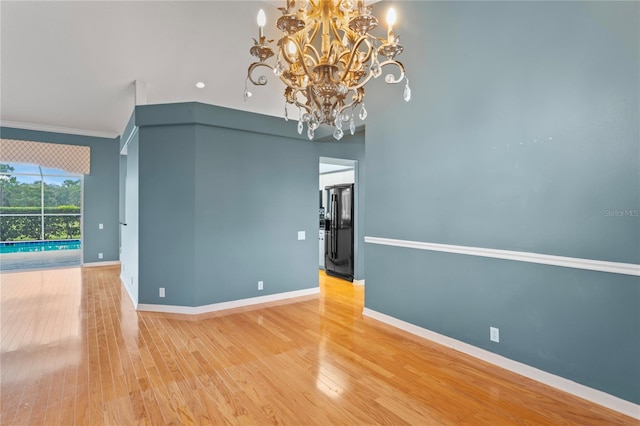 4351 Mallard Lake Dr, Spring Hill, FL 34609 - unfurnished room with a chandelier, wood finished floors, and ornamental molding