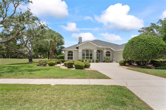 4351 Mallard Lake Dr, Spring Hill, FL 34609 - view of front of home featuring driveway, an attached garage, stucco siding, a front lawn, and a chimney