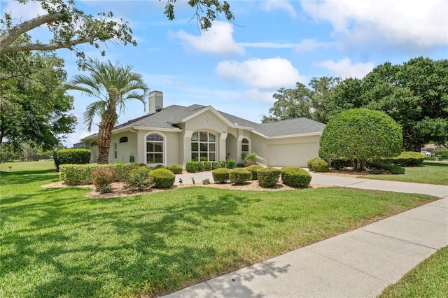 4351 Mallard Lake Dr, Spring Hill, FL 34609 - view of front of home featuring a garage, stucco siding, a front yard, concrete driveway, and a chimney