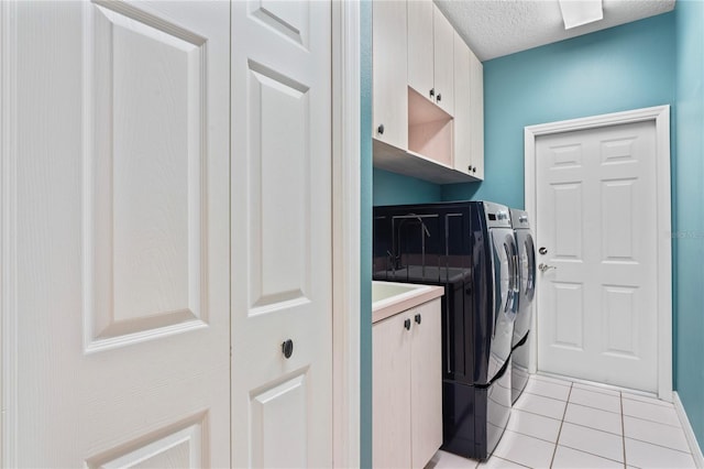 4351 Mallard Lake Dr, Spring Hill, FL 34609 - laundry area featuring washing machine and clothes dryer, cabinet space, light tile patterned floors, and a textured ceiling