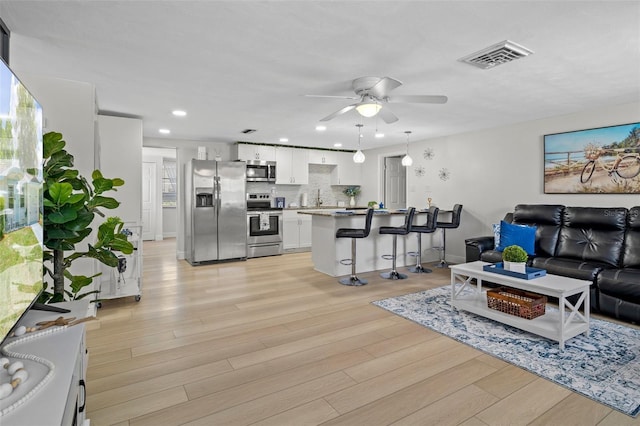 6144 Glenwood Dr, New Port Richey, FL 34653 - living room with ceiling fan, light wood-style floors, and recessed lighting
