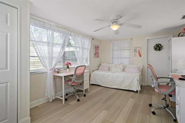 6144 Glenwood Dr, New Port Richey, FL 34653 - bedroom with light wood-style floors, a desk, and a ceiling fan