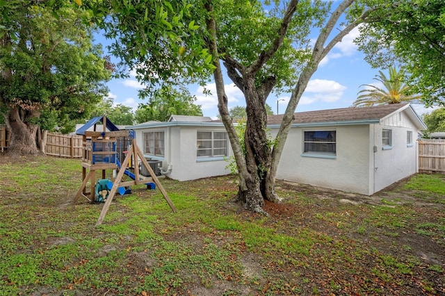 6144 Glenwood Dr, New Port Richey, FL 34653 - back of house with a playground, a fenced backyard, and stucco siding