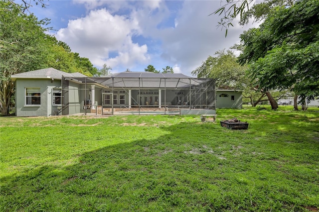 11510 Lakeview Dr, New Port Richey, FL 34654 - rear view of property featuring a lawn, an outdoor fire pit, an outdoor pool, glass enclosure, and a patio area