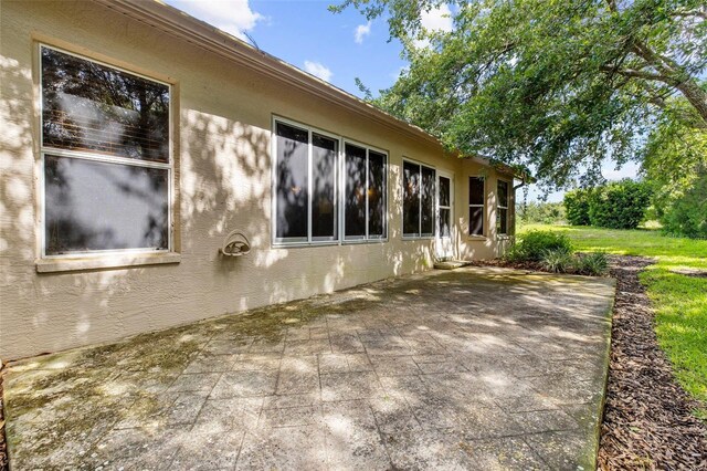 18736 Bent Pine Dr, Hudson, FL 34667 - view of side of home featuring a patio and stucco siding