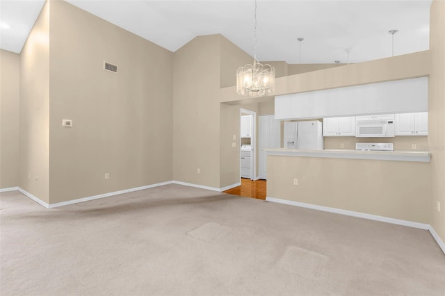 18736 Bent Pine Dr, Hudson, FL 34667 - unfurnished living room with light colored carpet, a chandelier, high vaulted ceiling, and washer / dryer