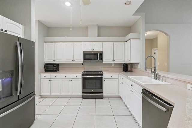 4052 Marine Pkwy, New Port Richey, FL 34652 - kitchen with appliances with stainless steel finishes, arched walkways, light countertops, white cabinets, and recessed lighting