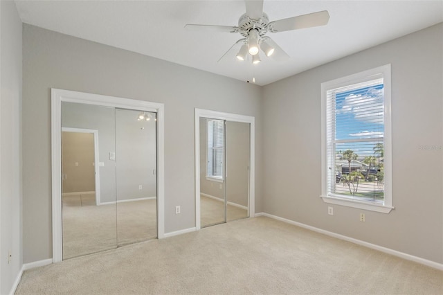 4052 Marine Pkwy, New Port Richey, FL 34652 - unfurnished bedroom featuring two closets, carpet flooring, and a ceiling fan