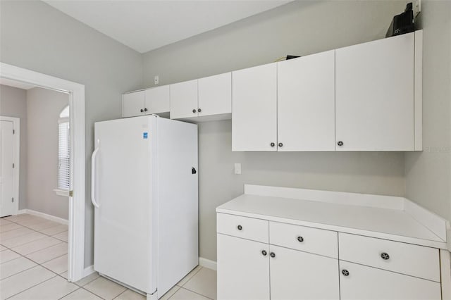 4052 Marine Pkwy, New Port Richey, FL 34652 - kitchen featuring freestanding refrigerator, light countertops, white cabinets, and light tile patterned flooring
