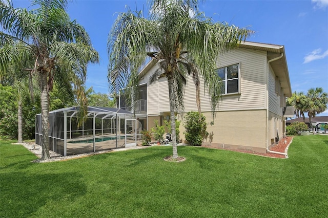 4052 Marine Pkwy, New Port Richey, FL 34652 - back of property featuring a lawn, an outdoor pool, and glass enclosure