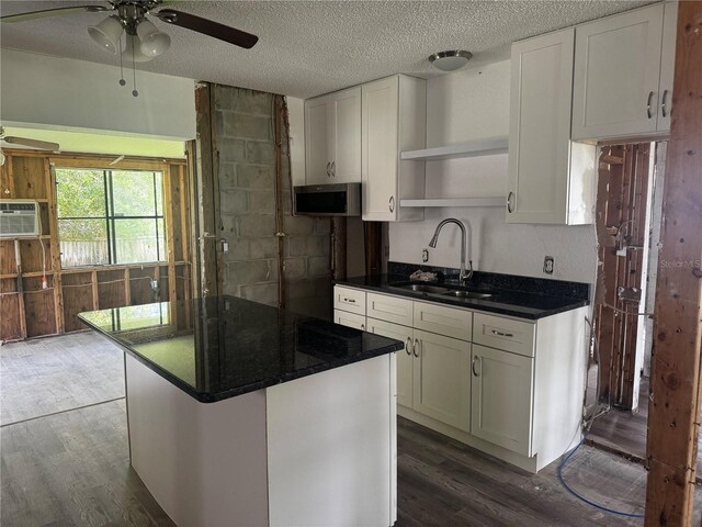 6826 Driftwood Dr, Hudson, FL 34667 - kitchen featuring open shelves, a ceiling fan, stainless steel microwave, dark wood-type flooring, and a textured ceiling