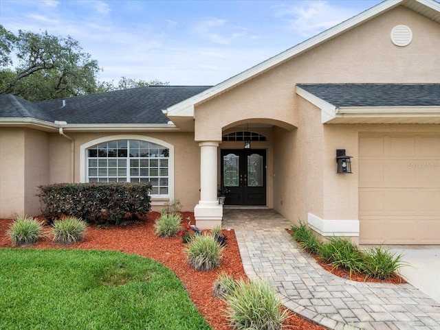 12060 Sapphire Dr, Spring Hill, FL 34609 - doorway to property featuring french doors, stucco siding, a shingled roof, and a garage