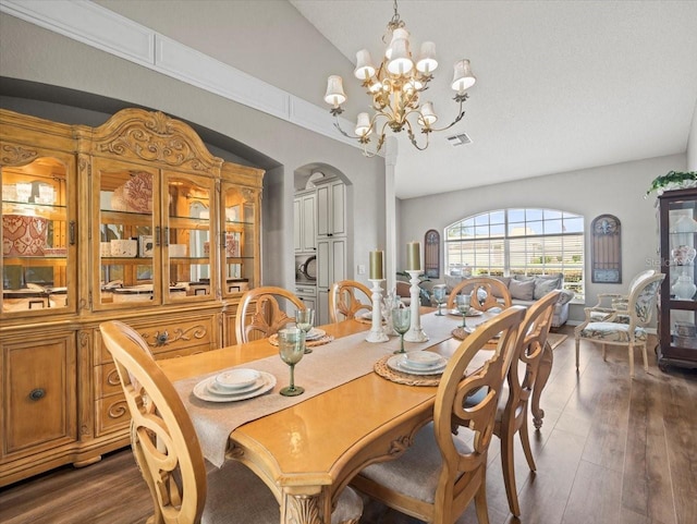 12060 Sapphire Dr, Spring Hill, FL 34609 - dining area featuring a chandelier, lofted ceiling, dark wood-type flooring, and arched walkways