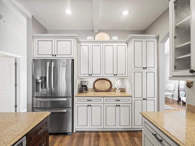 12060 Sapphire Dr, Spring Hill, FL 34609 - kitchen with stainless steel fridge, beamed ceiling, light stone counters, dark wood-style floors, and glass insert cabinets