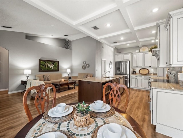 12060 Sapphire Dr, Spring Hill, FL 34609 - dining area featuring light wood-type flooring, recessed lighting, coffered ceiling, and beam ceiling