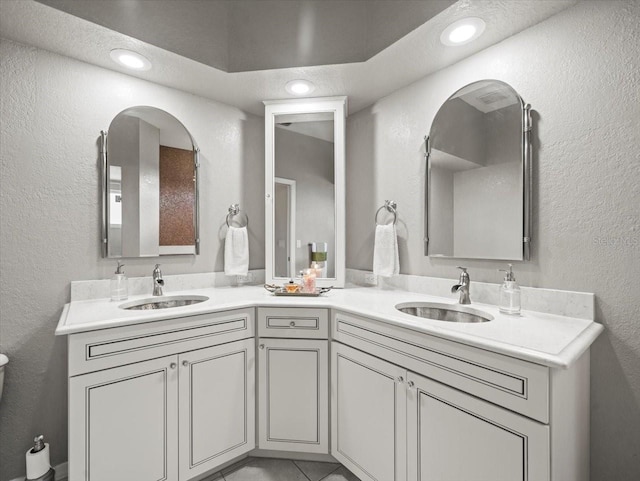 12060 Sapphire Dr, Spring Hill, FL 34609 - bathroom with double vanity, a textured wall, and recessed lighting