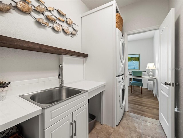 12060 Sapphire Dr, Spring Hill, FL 34609 - laundry area featuring stacked washer / drying machine, cabinet space, and a desk