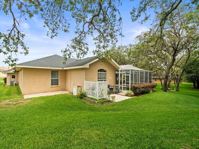 12060 Sapphire Dr, Spring Hill, FL 34609 - rear view of property with stucco siding, a yard, glass enclosure, and a patio