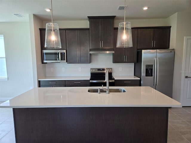 14425 Maiden Ter, Lakewood Ranch, FL 34211 - kitchen with appliances with stainless steel finishes, under cabinet range hood, tile patterned floors, a center island with sink, and light countertops