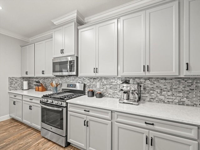 6130 Colmar Pl, Apollo Beach, FL 33572 - kitchen with appliances with stainless steel finishes, crown molding, backsplash, light wood-style floors, and light stone countertops