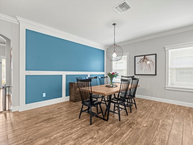 6130 Colmar Pl, Apollo Beach, FL 33572 - dining area featuring arched walkways, crown molding, and wood finished floors