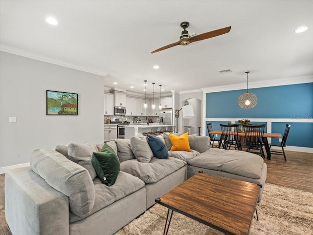 6130 Colmar Pl, Apollo Beach, FL 33572 - living area featuring ornamental molding, a ceiling fan, recessed lighting, wood finished floors, and arched walkways