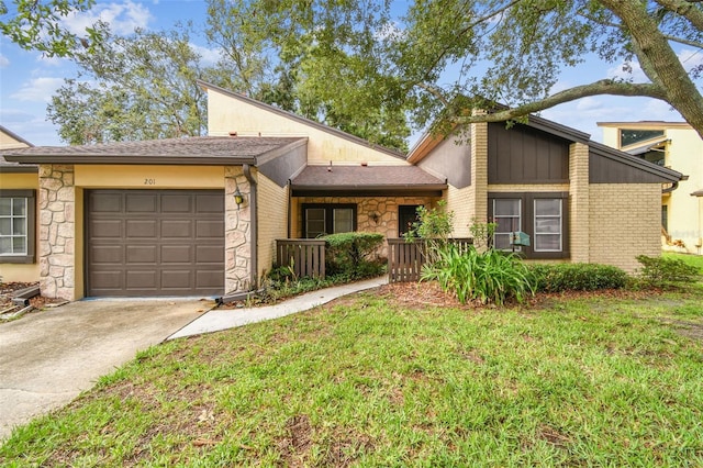 2101 Sunset Point Rd Unit 201, Clearwater, FL 33765 - mid-century inspired home with an attached garage, stone siding, concrete driveway, and a front yard