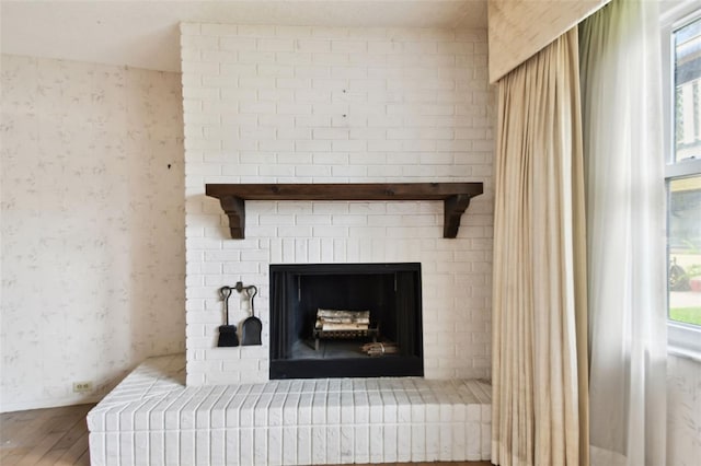 2101 Sunset Point Rd Unit 201, Clearwater, FL 33765 - detailed view of wallpapered walls, wood finished floors, and a brick fireplace