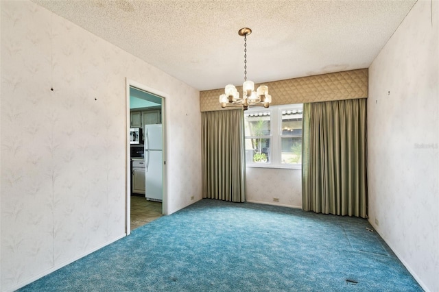2101 Sunset Point Rd Unit 201, Clearwater, FL 33765 - unfurnished room featuring a chandelier, wallpapered walls, carpet flooring, and a textured ceiling